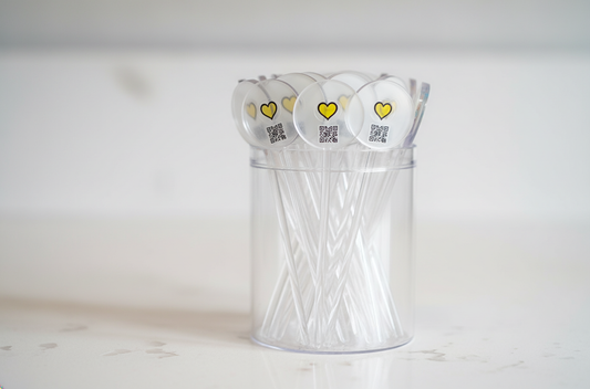 Clear plastic container with clear drink stirrers on a white background